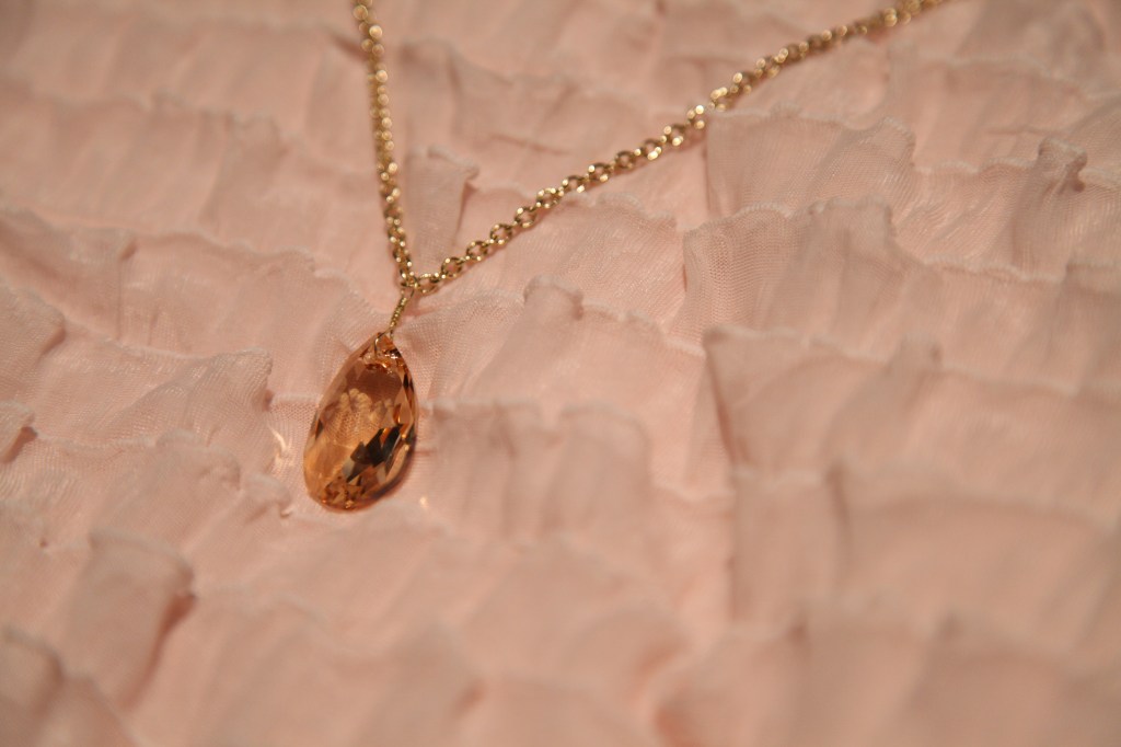 Queen (Swarovski light topaz pear crystal pedant on a simple gold plated chain 30" displayed)